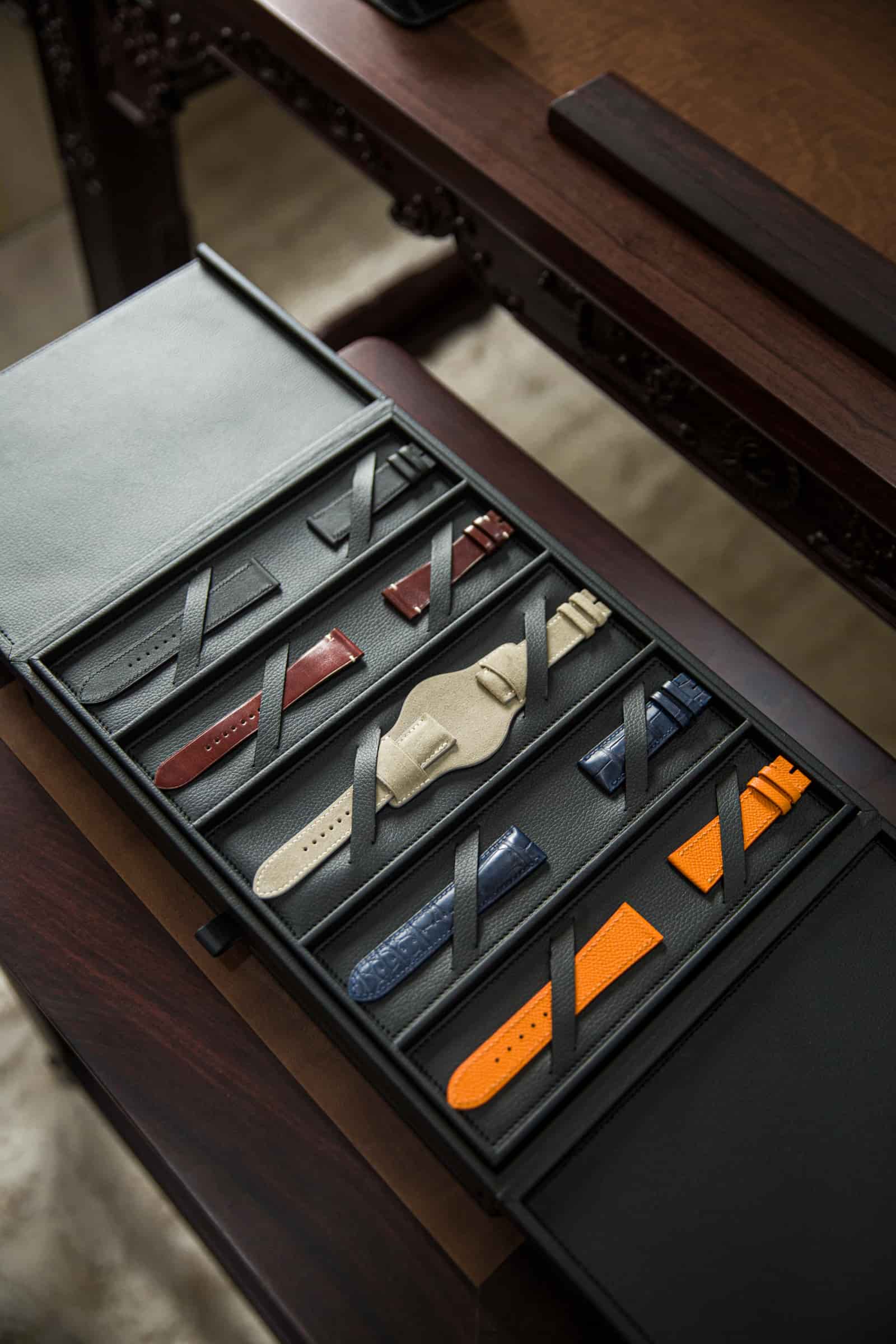 The sample box photographed upright on the workbench with its trays of coloured leather watch straps open